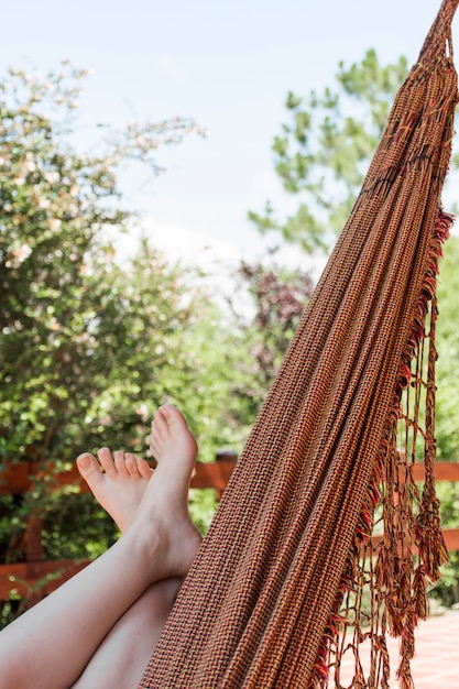 Free Photo woman lying in hammock on terrace in summer