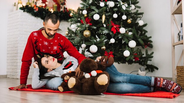 Woman lying on man near soft toys