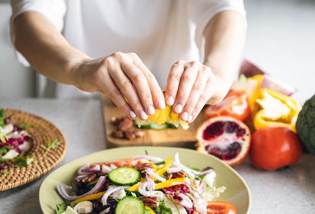 Free Photo a woman makes a fresh vegetable salad closeup