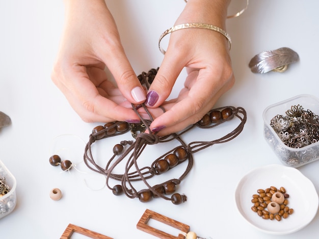 Woman making accessories with wooden beads