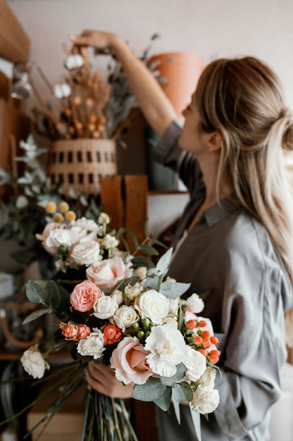 Free Photo woman making a beautiful floral arrangement