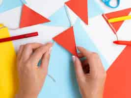 Free photo woman making decorations with red and blue paper