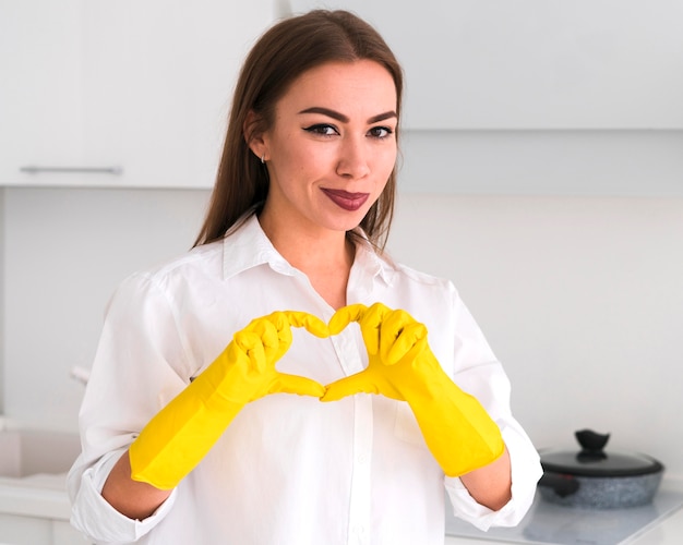 Woman making a heart shape with her hands medium shot