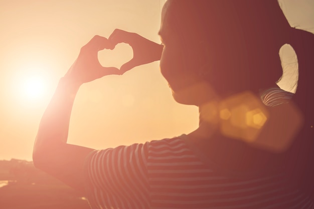 Free photo woman making a heart with her hands