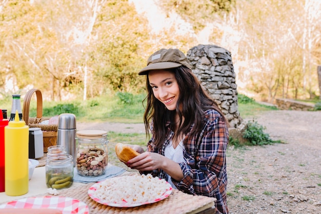 Free photo woman making hot dogs in nature