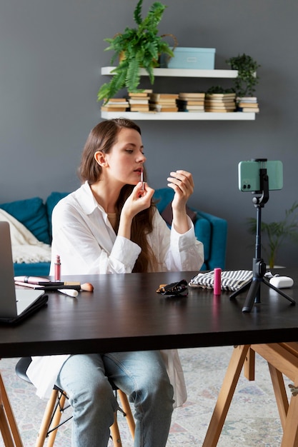 Free photo woman making a makeup vlog with her smartphone