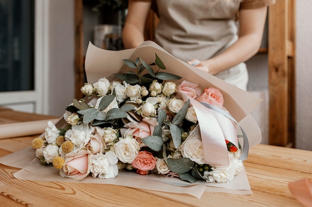 Free Photo woman making a pretty floral arrangement