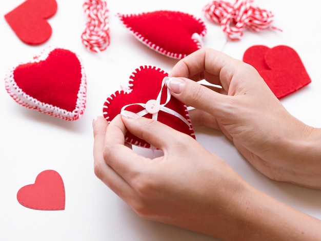 Free photo woman making red hearts decorations