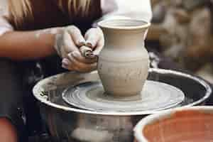 Free photo woman making a vase with clay