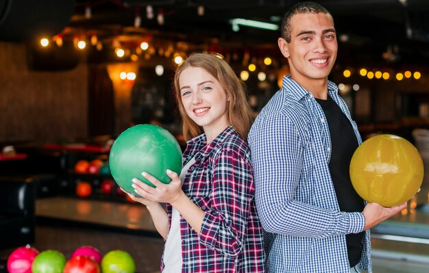 Woman and man holding the colorful bowling balls