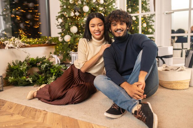 Woman and man looking at camera sitting on floor