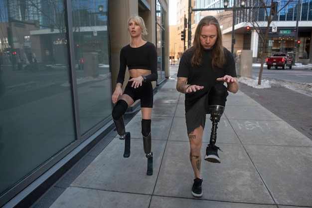 Free photo woman and man with leg disability exercising in the city