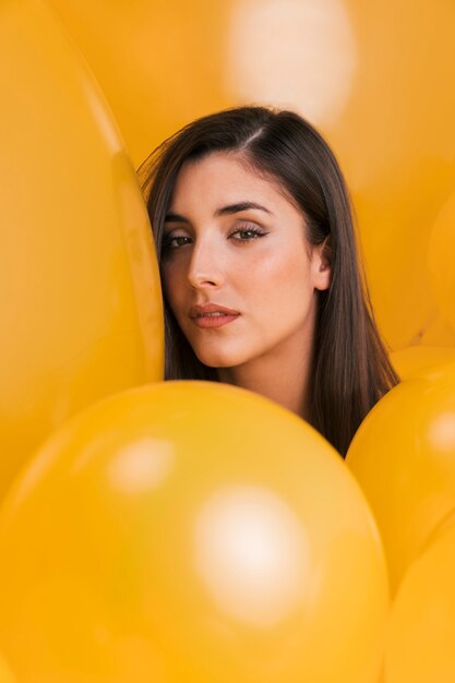 Woman between many yellow balloons