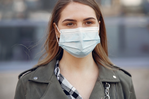 Woman in a mask stands on the street