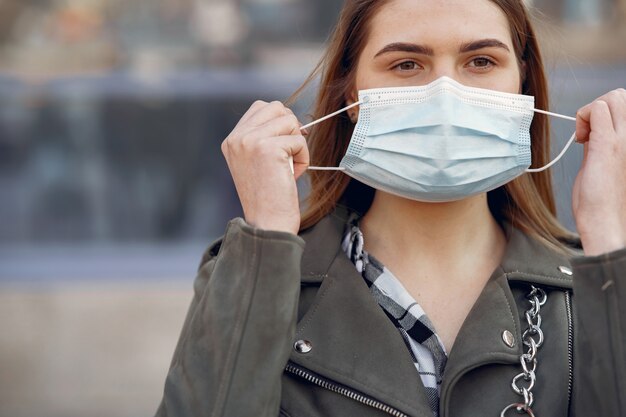 Woman in a mask stands on the street