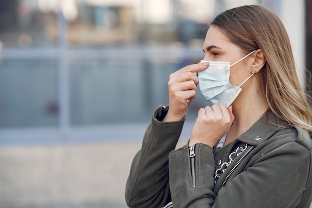 Woman in a mask stands on the street