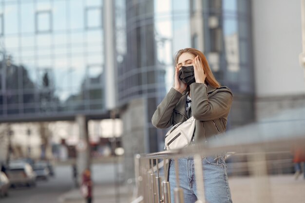 Woman in a mask stands on the street