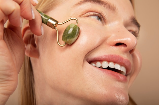 Woman massaging face with tool close up