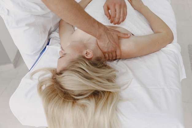 Woman in the medical office. Physiotherapist is rehabilitating back.