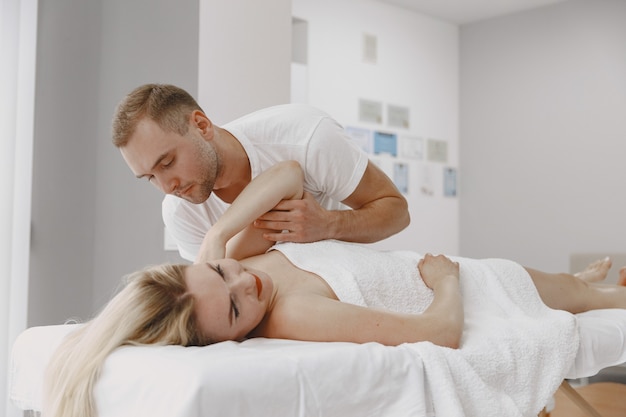 Woman in the medical office. Physiotherapist is rehabilitating back.