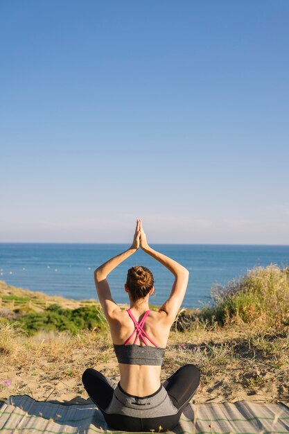 Woman meditating looking towards the sea