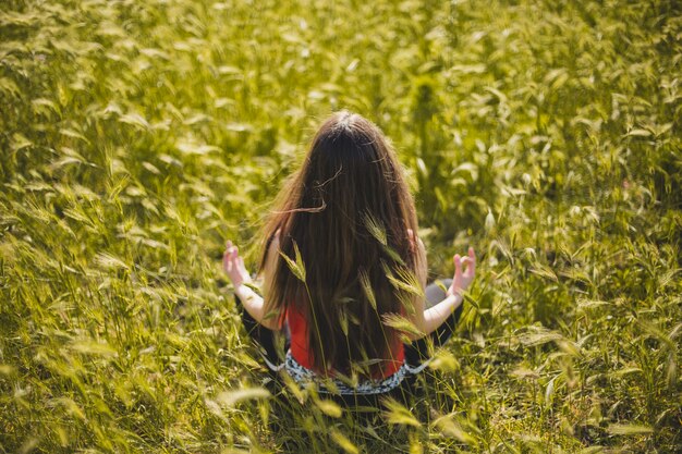 Woman meditating and relaxing in grass