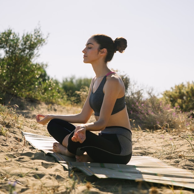 Woman meditating on the sand