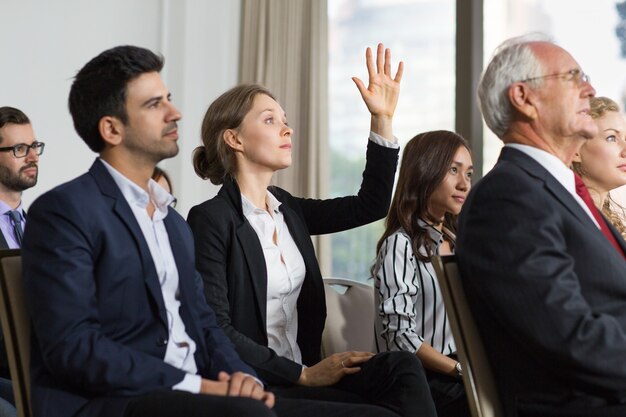 Woman in a meeting with raised hand