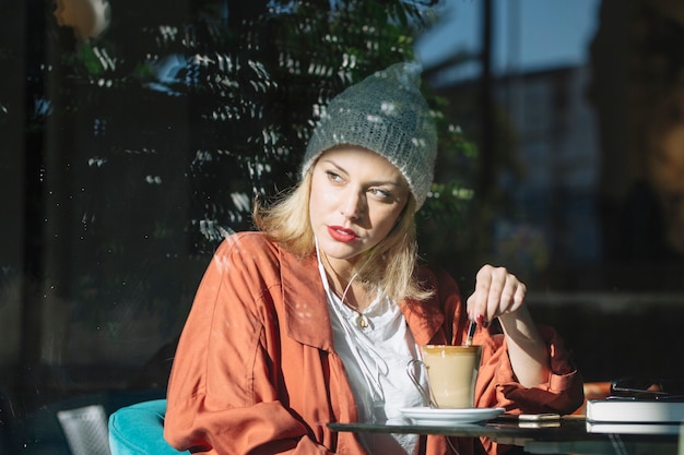 Woman mixing coffee in cafe