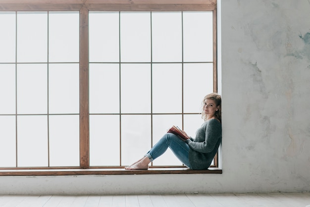 Woman near big window looking at camera