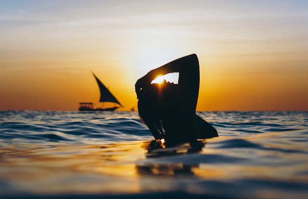 Woman in the ocean in the sunset time