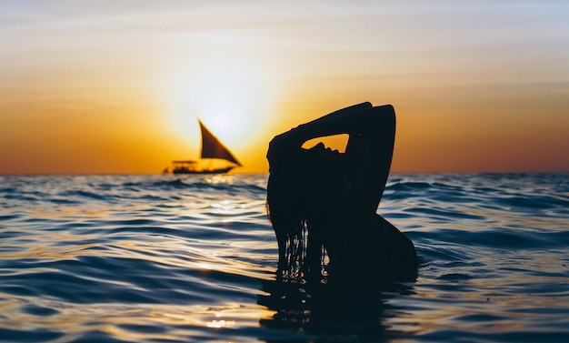 Free Photo woman in the ocean in the sunset time