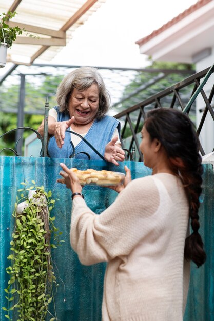 Woman offering food to neighbor