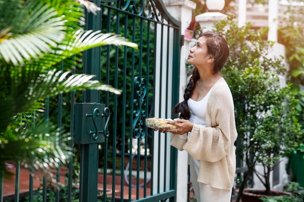 Woman offering food to neighbor