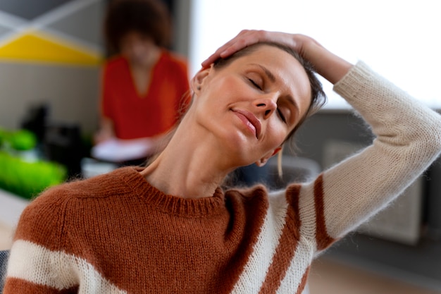 Free photo woman at the office stretching during a work day