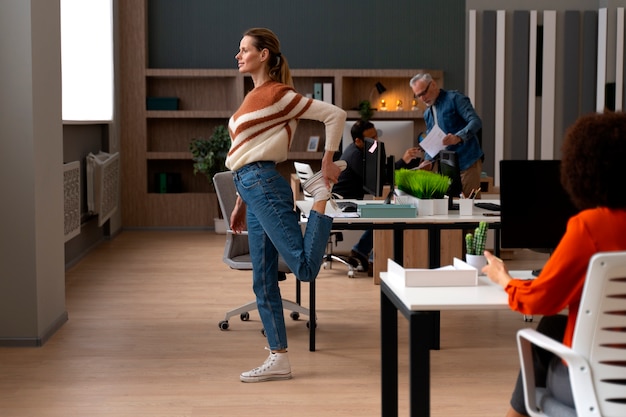 Free photo woman at the office stretching during a work day