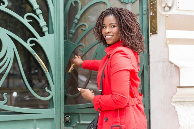 Woman opening door and smiling