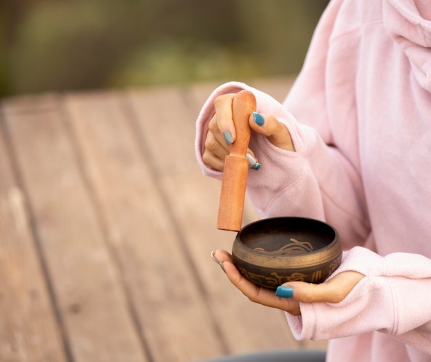 Free photo woman outdoors holding singing bowl with copy space