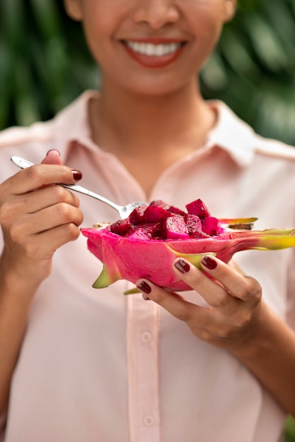 Free photo woman outdoors with dragon fruit