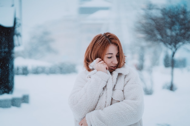 Woman outside on snowing cold winter day