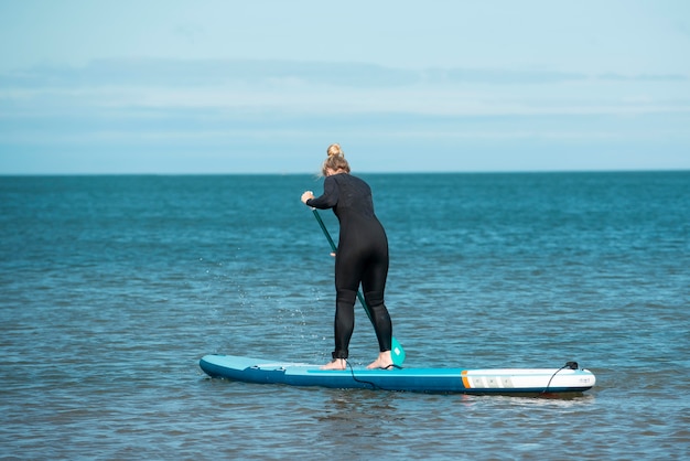 Free photo woman paddleboarding full shot