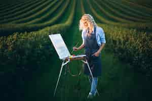 Free photo woman painter in a field