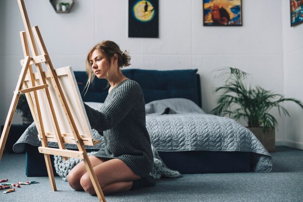 Woman painting in bedroom