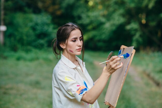 Woman painting on a brown surface