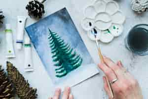 Free photo woman painting the christmas tree with paint brush