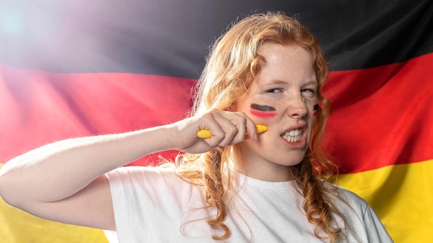 Woman painting german flag on her face