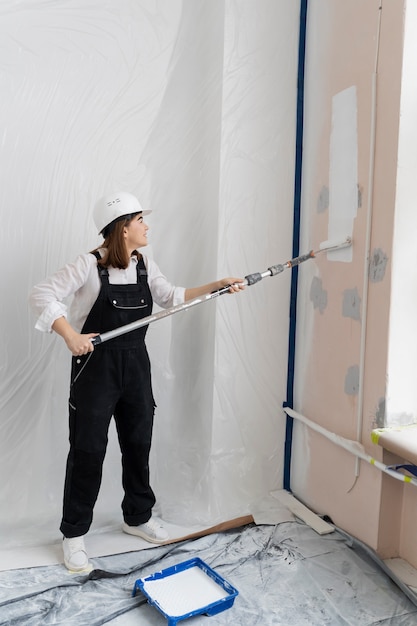 Free photo woman painting house wall full shot