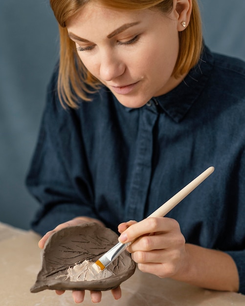 Free Photo woman painting leaf close-up