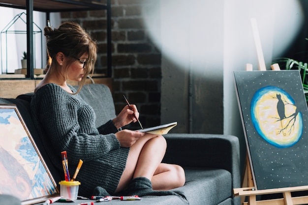 Woman painting in living room