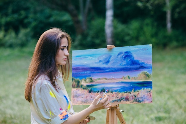 Woman painting a picture in the field